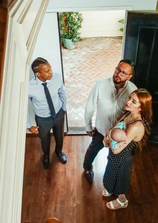 A family with a realtor exploring a new home's interior, considering a property purchase.